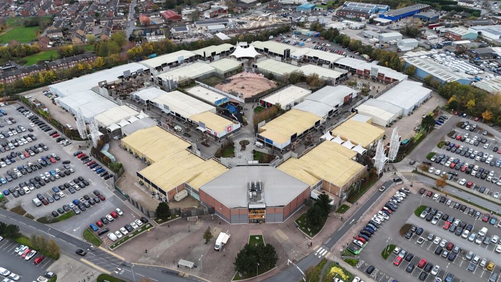 Explore the sprawling layout of Junction 32 Shopping Centre from an aerial perspective in West Yorkshire, England.
